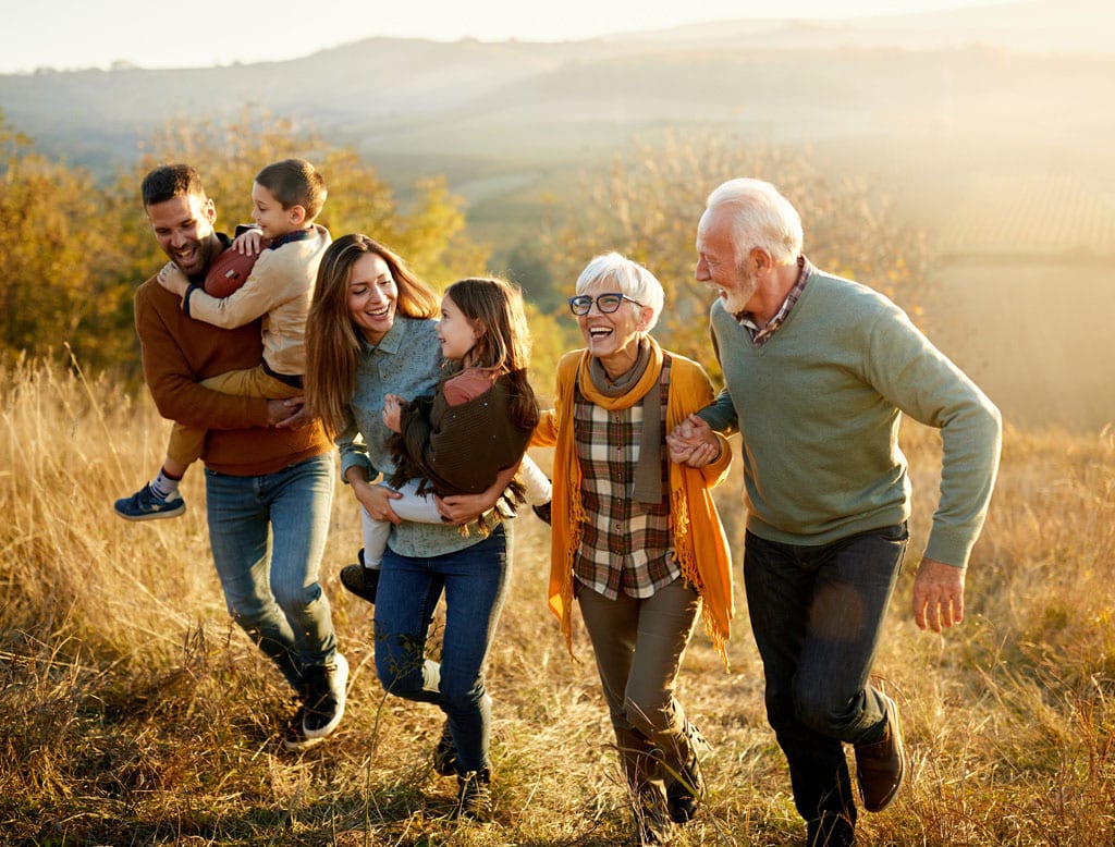 Group of a multi-generational family hiking in a hilly field